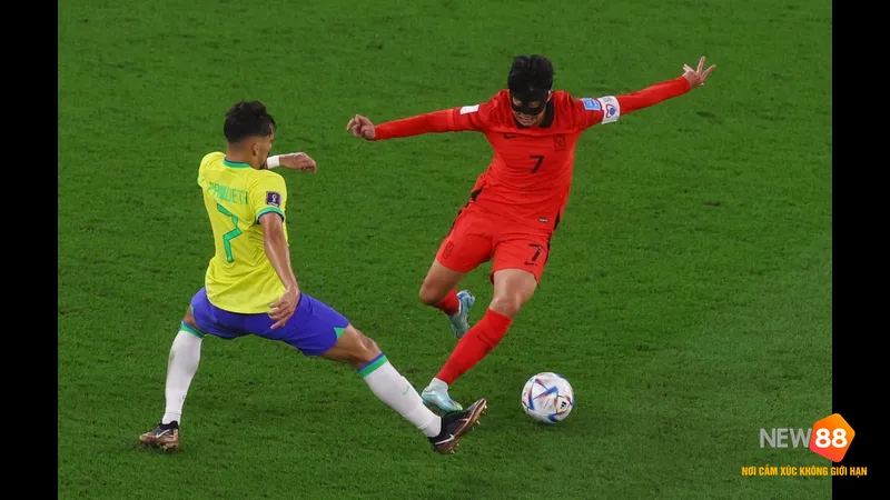 Cầu thủ H&agrave;n Quốc d&ugrave;ng kỹ thuật đi b&oacute;ng qua cầu thủ Brazil trong trận đấu b&oacute;ng đ&aacute;