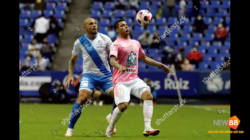 Một cầu thủ của Puebla v&agrave; Pachuca tranh chấp b&oacute;ng tr&ecirc;n s&acirc;n